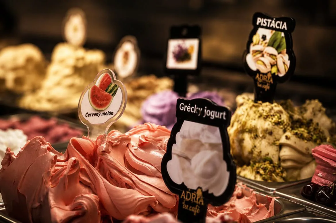 Detail kopčekovej zmrzliny vo vitríne — červený melón, grécky jogurt a pistácia
